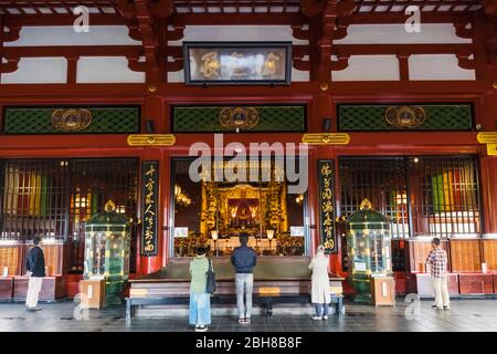Japan, Honshu, Tokyo, Asakusa, Sensoji Temple, People Praying inside The Main Hall Stock Photo