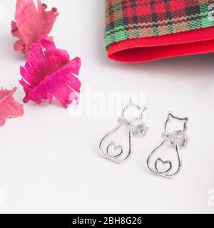 A pair of beautiful 925 sterling silver earrings in cat shape decorated with cubic zirconia isolated on white background Stock Photo