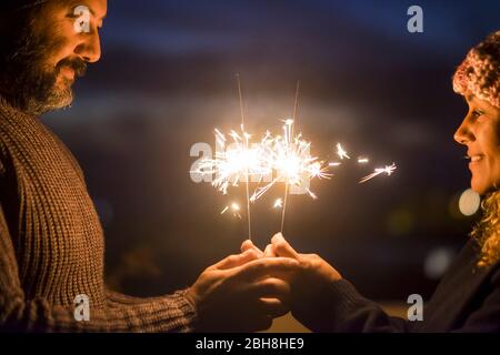 Valentine's day and love concept celebration for caucasian middle age beautiful couple enjoying together lifestyle and and togetherness life with sparklers light in the night - happy people Stock Photo