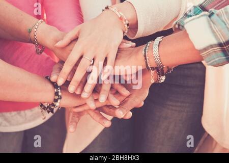 Teamwork and friendship together concept with hands put on hands - women power day for work and friends - caucasian people team in vintage filter colors Stock Photo