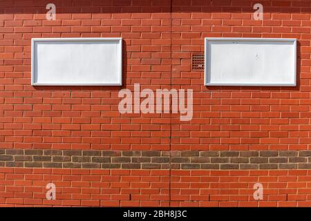 a close up view of two empty poster clip boards that are attached to a brick wall Stock Photo
