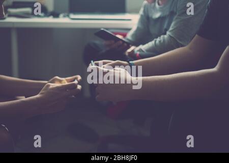 Close up of three device with video games for young caucasian friends playing together at home like technology addicted with mobile phone and internet connection - millennial boy concept Stock Photo