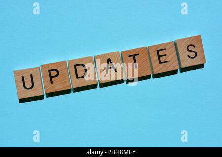 Updates, word in wooden alphabet letters isolated on blue background with copy space Stock Photo