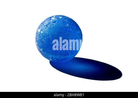 Close up still life of a chipped blue glass marble and the shadow it casts in directional sunlight, isolated against a white background. Stock Photo