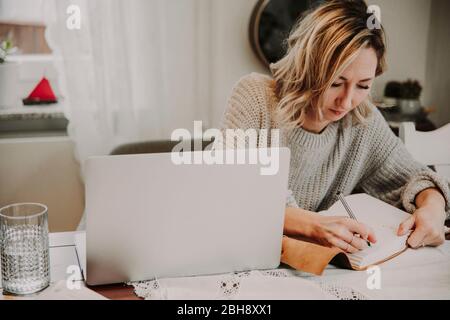 Frau mit Laptop und Notizbuch Stock Photo