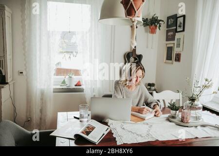 Frau mit Laptop und Notizbuch Stock Photo