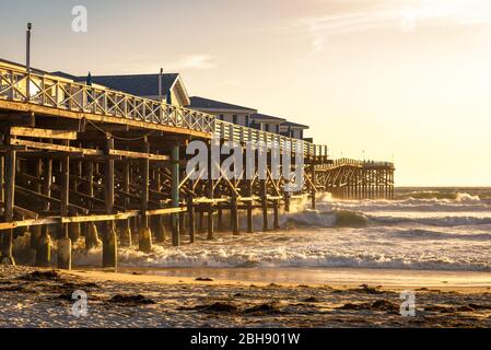 Seitenansicht vom historischen hölzernem Crystal Pier in San Diego bei Sonnenuntergang, stürmischer Pazifischer Ozean Stock Photo