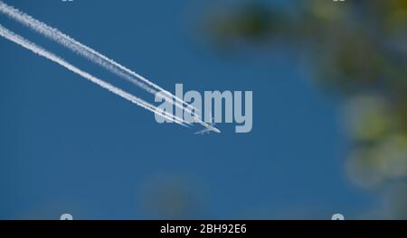 London, UK. 24th April 2020. Day 32 of Coronavirus lockdown in UK, and Singapore Airways aircraft overflies London at altitude with vapour trail eastbound. Credit: Malcolm Park/Alamy. Stock Photo