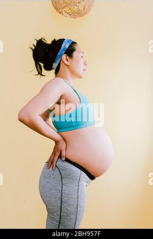 Pregnant Woman with Hands on her Back Stock Photo