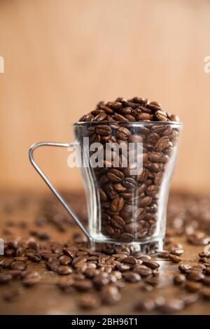 Transparent glass cup filled with coffee beans Stock Photo