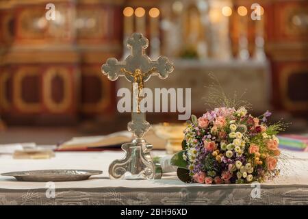 Bridal bouquet is on altar beside the altar cross Stock Photo