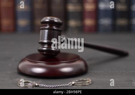 Law and Justice, Legality concept, Judge Gavel and Handcuffs on a black wooden background. Stock Photo