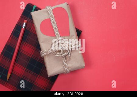 directly above shot of valentine day gift, notepad and pencil on red  Stock Photo