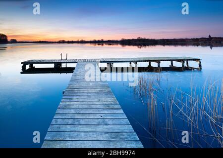 Sunset at the Krakower lake in winter, boardwalk, ice on the water, Mecklenburg-Vorpommern, Germany Stock Photo