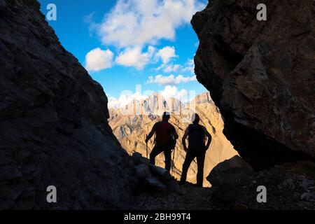 Two hikers looking the Gran Vernel group in a small fork along the Bepi Zac High Trail, Costabella Ridge, Marmolada group, Dolomites, Fassa Valley, Trento province, Trentino-Alto Adige, Italy Stock Photo