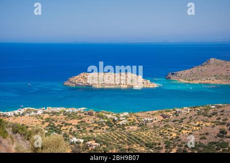 View of the island of Spinalonga with calm sea. Here were isolated lepers, humans with the Hansen's desease, gulf of Elounda, Crete, Greece. Stock Photo