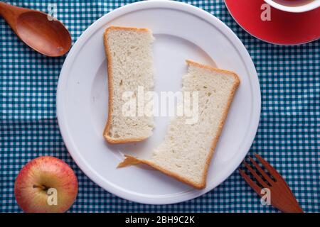 Half slice of bread in a plate on table. Stock Photo