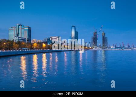 Azerbaijan, Baku, Bulvar Promenade, city skyine from Baku Bay, dusk Stock Photo
