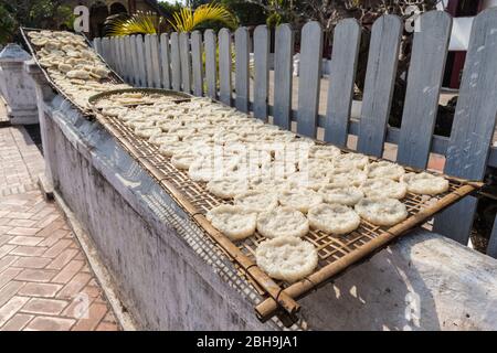 Laos, Luang Prabang, sticky rice cakes, Buddhist monk alms offering, drying in the sun Stock Photo