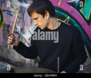 Young man playing drums in an underground environment Stock Photo