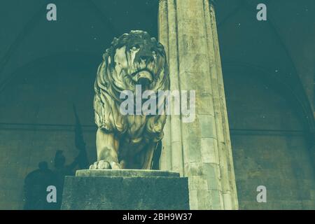 A lion, a sculpture at the Feldherrenhalle, next to the church St. Kajetan, the Theatinerkirche corner Hofgarten in Munich, Bavaria, Germany. Stock Photo