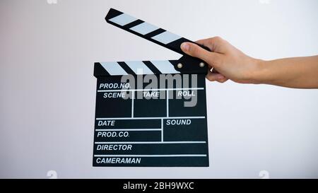 Hands holding clapperboard isolated on white background. Stock Photo