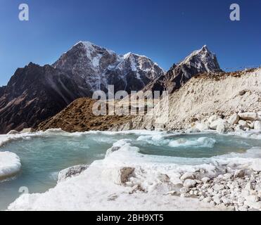 Creek with first snow in the Himalayas, lodge in the background Stock Photo