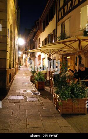 France, Alsace, Strasbourg, old town, narrow lane, pedestrian area, street restaurant, guests, in the evening Stock Photo