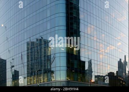 The tinted windows of a skyscraper facade on Fenchurch Street in London with reflections of high-rise buildings in the windows Stock Photo