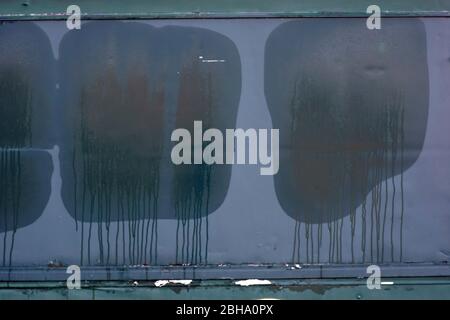 A closed gray trailer made of sheet metal and a stall for fan merchandise forms wet window prints on the shutter in rainy weather. Stock Photo
