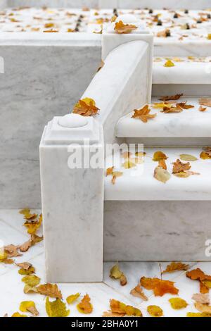 Close up of white marble fountain at the public Summer Garden in St. Petersburg. The fountain is off for the winter, dry fallen leaves on the steps. Stock Photo