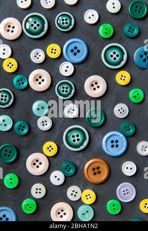 Colorful mixed sewing buttons on black background, flat lay. Top view. Stock Photo