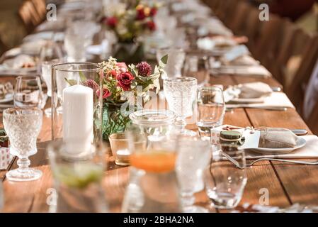 Ceremonial wedding table with floral decorations and glasses in a rustic style, close-up Stock Photo