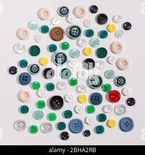 Colorful mixed sewing buttons on white background, flat lay. Top view. Stock Photo