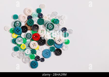Colorful mixed sewing buttons on white background, flat lay. Top view with copy space Stock Photo