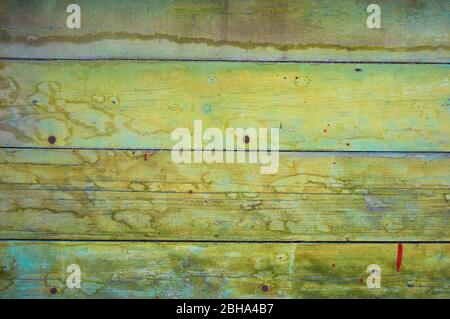 Old wooden board painted in green color with scratches and chips. Stock Photo