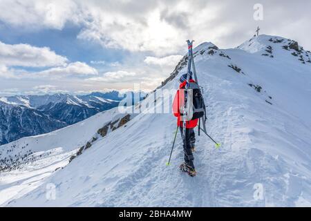 Ski mountaineer on the backpack on the final ridge to the summit of Monte Alto (High Man), Hohe Tauern, Casies valley / Gsieser valley, South Tyrol, Italy Stock Photo