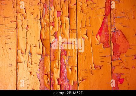 Color on wood chipped and weathered red orange yellow Stock Photo