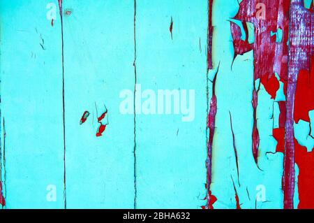 Old wooden board painted in green and red color with scratches and chips. Stock Photo