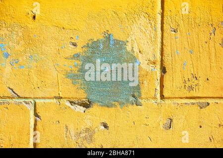 Yellow wall with scratches and chips. Abstract background. Stock Photo