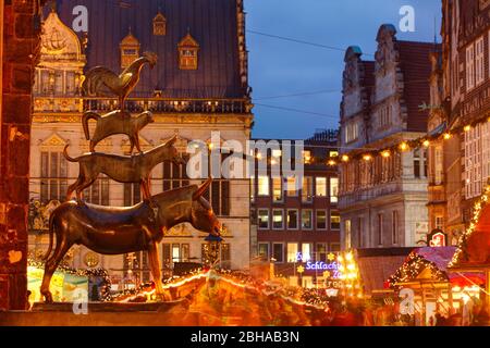 The Bremen Town Musicians and Christmas Market with Haus Schütting, Market place-Westseite and Obernstraße at dusk, Bremen, Germany Stock Photo