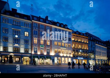 Germany, Bavaria, Munich, residential street, shops, row of houses, in the evening Stock Photo