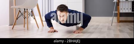 Office Workout Exercise. Healthy Man Doing Pushups Stock Photo