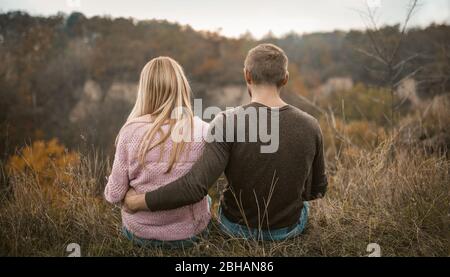 Couple In Love Sitting In Nature, View From Back Stock Photo
