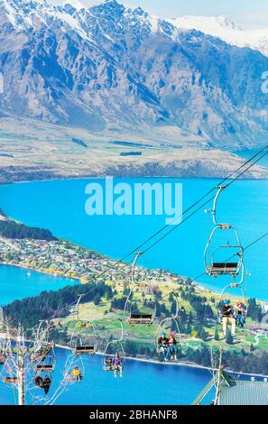 Luge riders taking lift up to top of hill, Queenstown, South Island, New Zealand, Stock Photo