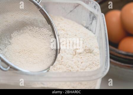 Flour in a plastic bowl close up with some ingredients for baking needs Stock Photo