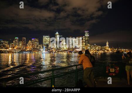 People looking at illuminated city at night, Seattle, Washington, USA Stock Photo