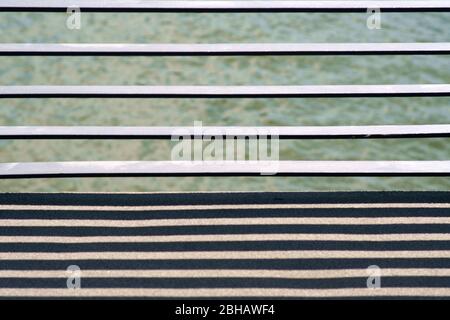 The close-up of the cross struts of a bridge railing casting symmetrical shadows. Stock Photo