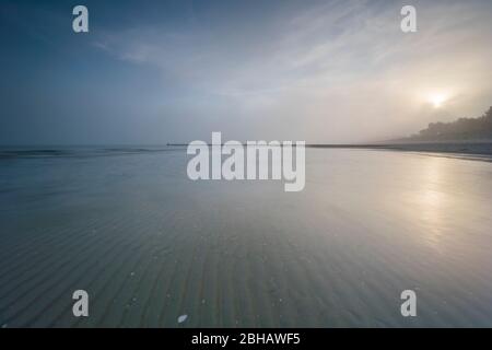 Sunrise in the winter by the sea with a falling mist of bright sun on a beautiful winter day Stock Photo