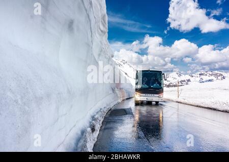 touring coaches near the Hochtor pass with very high snow on the sides of the wet road, Grossglockner High Alpine Mountain Road, Hohe Tauern National Park, Salzburg, Austria, Europe